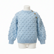 Light blue knitted sweater with textured pattern on a mannequin against a white background

