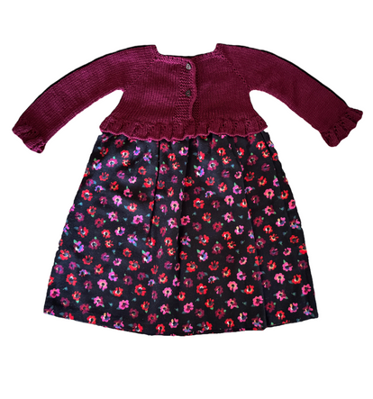Burgundy knitted outfit with a colorful patterned blanket on a white background

