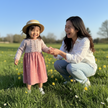 Woman and child holding hands in a grassy field with yellow flowers