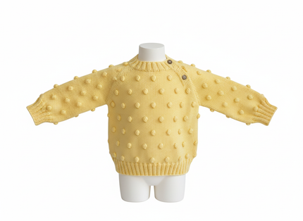 Yellow polka dot sweater on a mannequin against a white background

