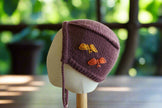 Hand-Knitted Bonnet in Deep Plum with Embroidered Butterflies

This charming hand-knitted bonnet in a rich deep plum hue exudes warmth and elegance, making it a perfect accessory for little ones. Adorned with delicate hand-embroidered butterflies in warm autumn shades of golden yellow and burnt orange, it adds a whimsical and nature-inspired touch. The bonnet features a snug fit with soft ties to ensure comfort and security. A timeless piece designed to keep your child cozy while embracing a classic, handcr