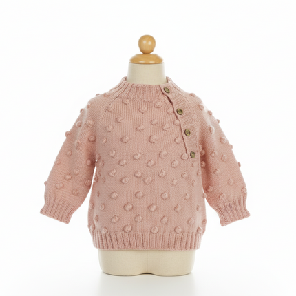 Pink knitted sweater with bobble texture on a mannequin against a white background

